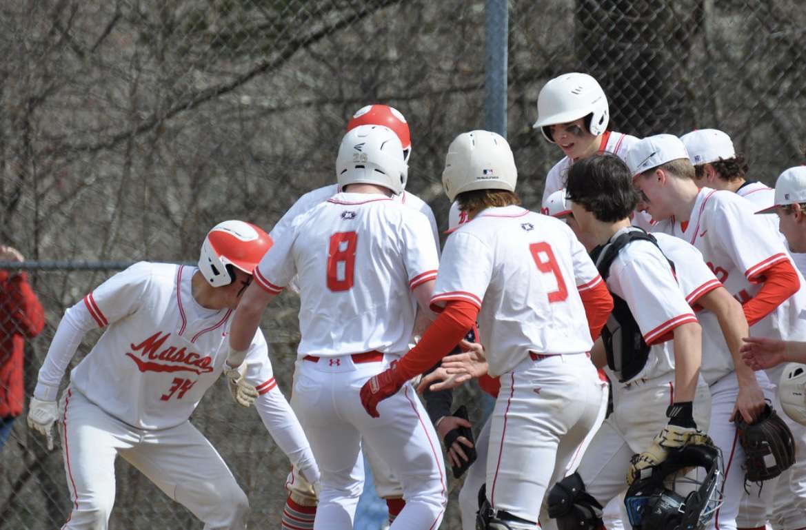 #8 Freshman Davis Deluties celebrating with his teammates at home plate after first homerun