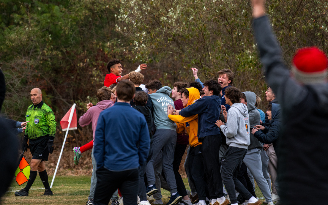 Masco's Enzo Nteta and Jack Fielder jumping into the student section after Fiedler's goal