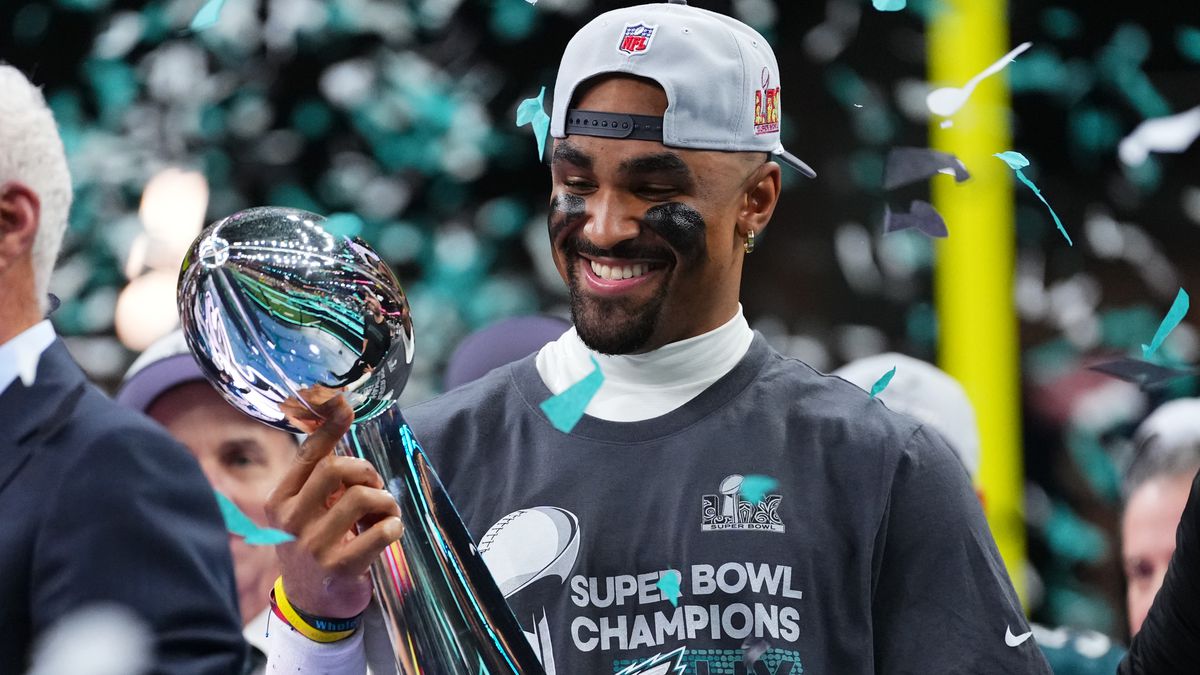 Jalen Hurts hoists the Lombardi Trophy as confetti rains from above